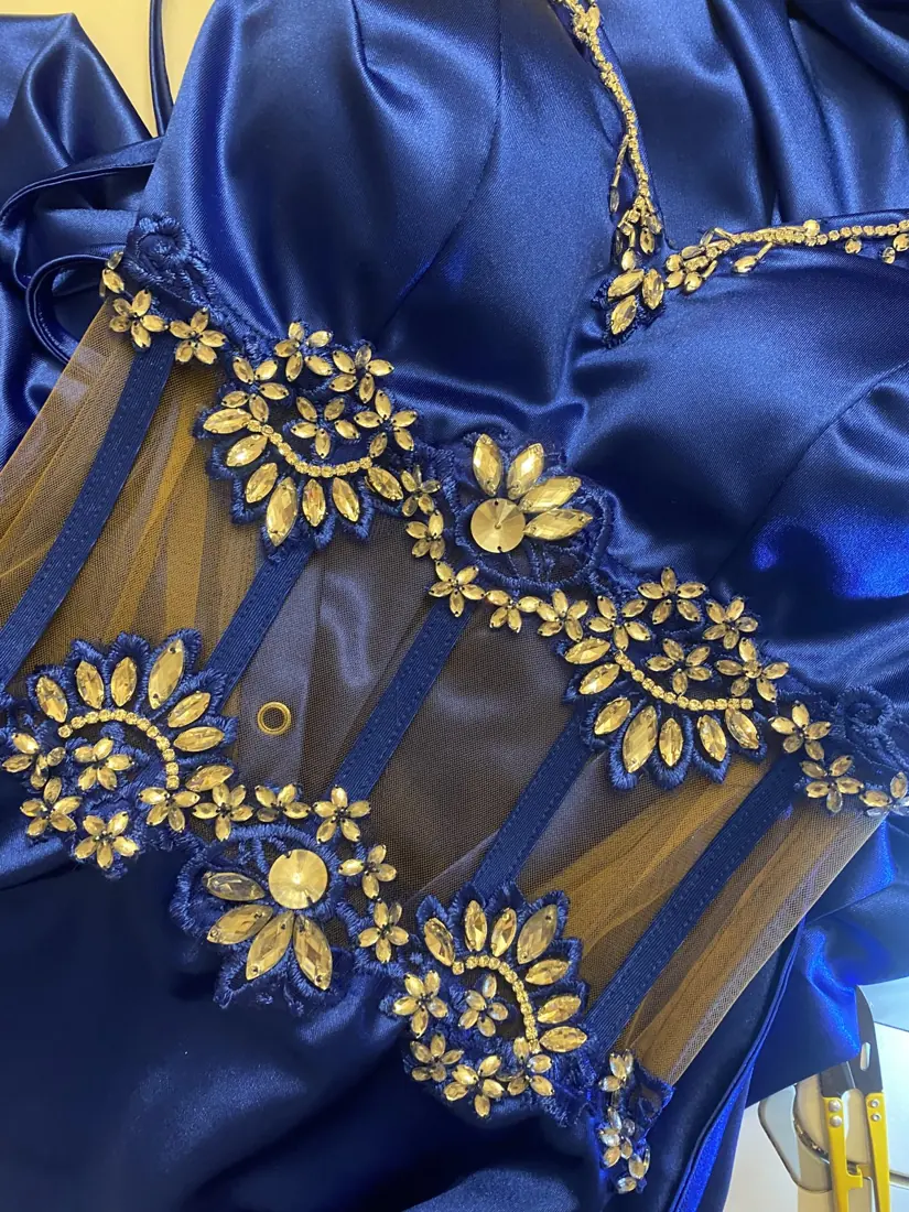 Detalle de bordado dorado sobre raso azul