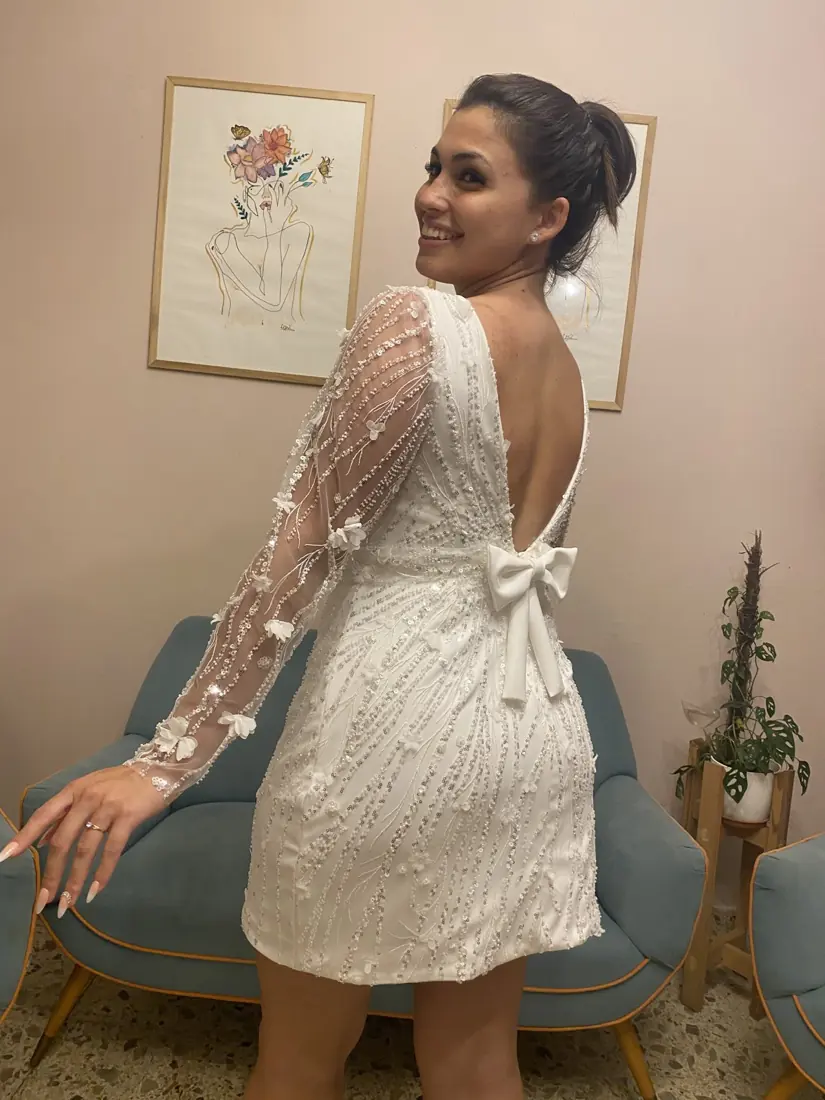 Novia corta con mangas de tul y moño en la espalda